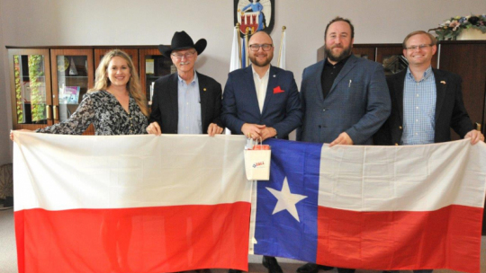Teksańska delegacja z prezydentem Torunia i flagami obu państw